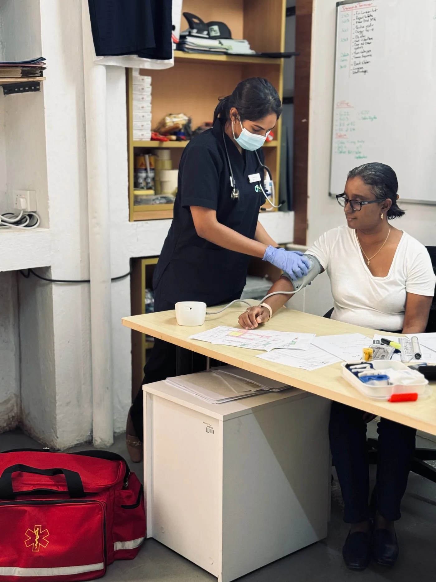 An OCS Médecins doctor checking an employee's blood pressure at their workplace