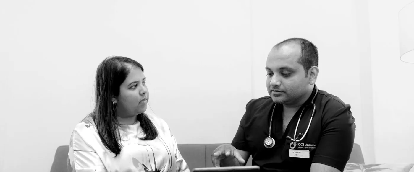 An OCS Médecins doctor explaining a treatment plan to a patient at home