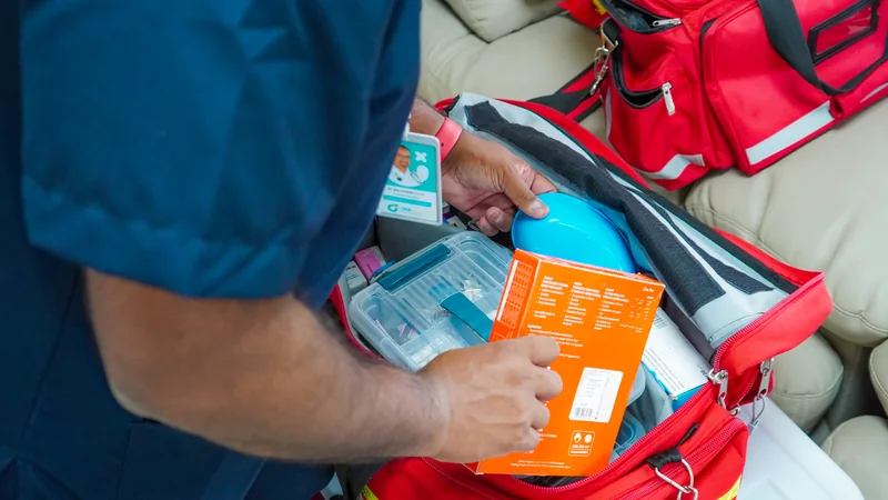 OCS clinician checking supplies in a red medical bag.